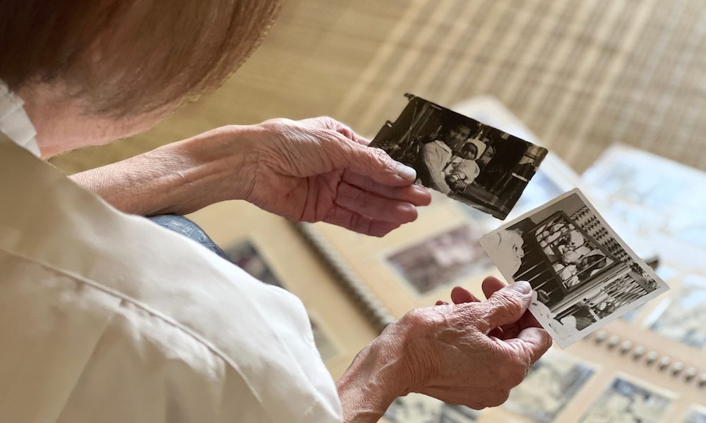 たくさんのアルバムを広げて写真を見る高齢女性の手元 Electrical brain stimulation may improve memory in older adults