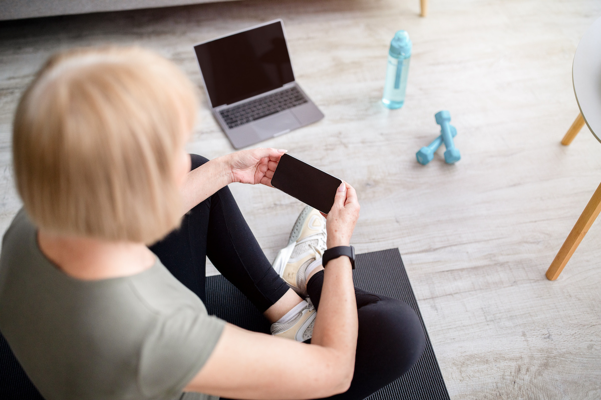 Older lady using a fitness programme on mobile phone